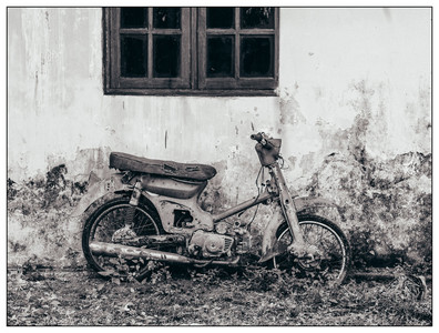 Bali- An old scooter left leaning against a wall-06282022.jpg